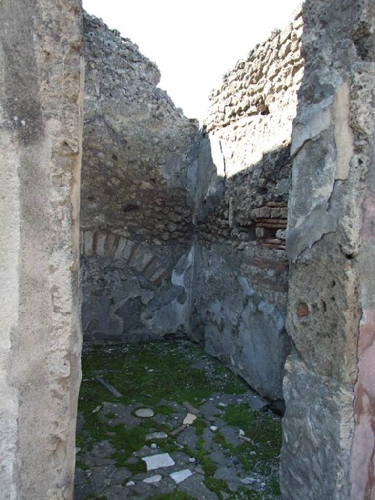 VIII.4.4 Pompeii. March 2009. Room 23, north-west corner of room linked to VIII.4.3.
According to Fiorelli, this room was excavated on the dates of 9th and 18th January and 6th February 1861, and had two doors, one linking to the shop at VIII.4.3 and the other into the atrium of VIII.4.4. It was found decorated only with white walls with some red lines and yellow meanders, in the middle were two painted candelabra, a large urn and another vase of uncertain form; there were no central paintings on its walls. The beaten floor had a few pieces of coloured marble in it, the threshold was of vesuvian stone, the lower podium of the walls were carelessly painted with the same aquatic plant leaves that were seen in the atrium. Remaining in their original site were – the bronze hinges of the two doors, and with them the locks, three nails, and a ring with flange, other iron nails, four pieces of cylindrical bone, and a terracotta jar in the form of an “ampulla”.
See Fiorelli, Giornale degli Scavi, 1861, (p.19)
