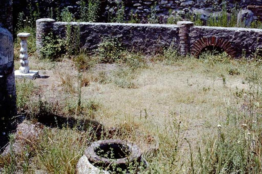 VIII.4.12 Pompeii, 1968. Looking west across portico. Photo by Stanley A. Jashemski.
Source: The Wilhelmina and Stanley A. Jashemski archive in the University of Maryland Library, Special Collections (See collection page) and made available under the Creative Commons Attribution-Non-Commercial License v.4. See Licence and use details.
J68f1200
According to Wilhelmina, this was a shop-house, with the garden (excavated in 1861) at the rear at the back of two shops (VIII.4.12 and 13).
The garden had a portico on four sides. Seven huge dolia were buried in the soil along the edge of the east half of the garden.
In the south-west corner there was a masonry pool with a little column in the middle, which jetted water. A marble monopodium was also found.
On the right side of the peristyle there was a bronze basin (0.40m in diam.) with a hole in the middle through which a small pipe entered.
On the pipe was a little lion which jetted water from its mouth and throat. The feet of the basin were welded in the form of a ring.
The fragment of a head of a statuette was also found on the right side of the peristyle.
See Jashemski, W. F., 1993. The Gardens of Pompeii, Volume II: Appendices. New York: Caratzas. (p.213).