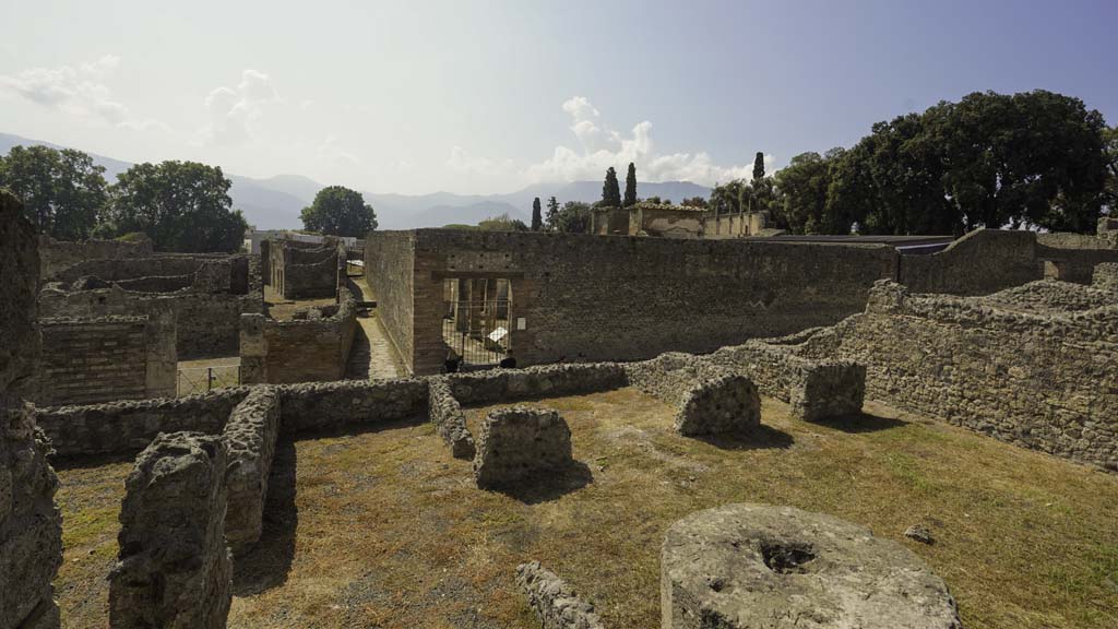 VIII.4.15 Pompeii. August 2021. Looking south from south portico onto lower level of VIII.4.27/29. Photo courtesy of Robert Hanson.
VIII.4.27’s rear entrance at VIII.4.29 is seen on the south side of peristyle, towards the right.
Opposite, on the other side of Via del Tempio d’Iside, is the entrance to the Temple of Isis.