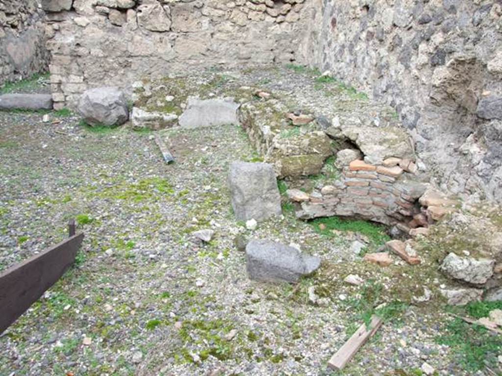 VIII.4.35 Pompeii. Shop and room. December 2007. North east corner of shop. Remains of two sided podium or counter with a furnace and tub.