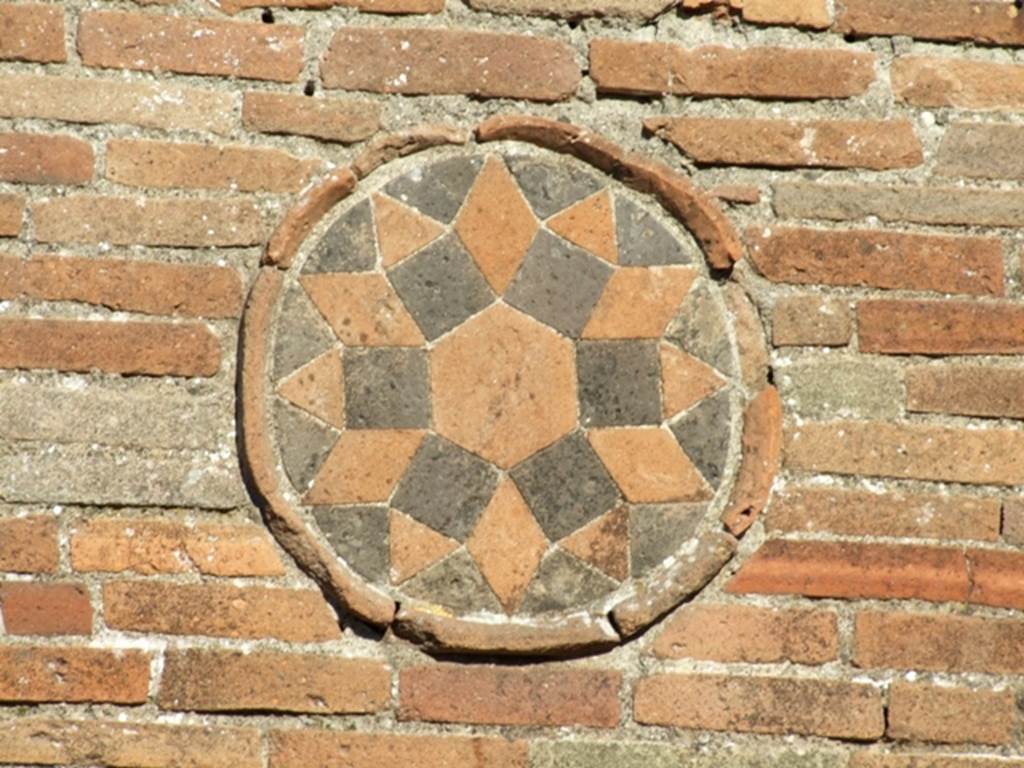 Geometric plaque on side wall of VII.4.1 near entrance to VIII.4.53. March 2009.