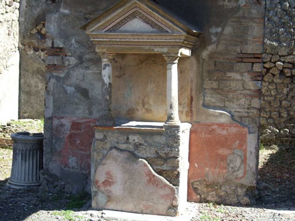VIII.5.37 Pompeii. March 2009. Room 1, aedicula lararium in atrium.
On the front of the podium was a painted round altar flanked by two serpents. On the altar Two eggs and a pine cone were painted on the altar. See Fröhlich, T., 1991. Lararien und Fassadenbilder in den Vesuvstädten. Mainz: von Zabern. (L96, T: 8,3).
According to Boyce, this aedicula lararium had paintings and statuettes when found. The tympanum was white, bordered with a red stripe and painted on it were small gladiatorial arms. In the middle a helmet, to the left greaves, and to the right a shield and above it a dagger. Mau thought because of these paintings, the owner of the house may have been a retired gladiator. On the back wall within the aedicula was the lararium painting consisting of Genius and two Lares. When excavated, six bronze statuettes were found in this aedicula. They were of Aesculapius, Apollo, Mercury, Hercules and the two Lares. In addition to the statuettes, a bronze lamp with a crescent moon on its handle was also found.
See Boyce G. K., 1937. Corpus of the Lararia of Pompeii. Rome: MAAR 14. (p.77, no.371, and Pl.31, 1 and 2).