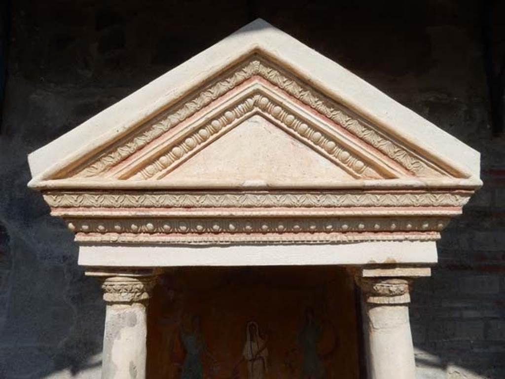 VIII.5.37 Pompeii. May 2017. Detail of the aedicula lararium and ornamental triangular panel. The tympanum (the triangular panel) was white, and bordered with a red stripe and painted on it when found were small gladiatorial arms. In the middle a helmet, to the left greaves, and to the right a shield and above it a dagger. Photo courtesy of Buzz Ferebee.