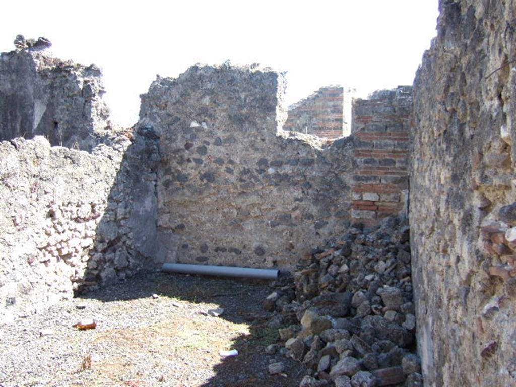 VIII.6.11 Pompeii. September 2005. Room on south side of entrance, according to Eschebach – a stable?. See Eschebach, L., 1993. Gebäudeverzeichnis und Stadtplan der antiken Stadt Pompeji. Köln: Böhlau. (p.386)
According to Mau, the use of room “f” was unknown. It was found without any other decoration than a zoccolo as in room “e” (made of a reddish stucco made by the addition of brick dust), and had a separate entrance from the western roadway. On entering the doorway from the roadway, on the right was a staircase (two stone steps, the reminder made of wood) to the upper floor. On the left was the toilet, from which in order to reach “f”, you had to go down 0.60m. See BdI, 1884, p.139
(È ignota del pari la destinazione di “f”, senz'altra decorazione che uno zoccolo come quello di “e”; ha un ingresso separato dal vico occidentale, entrando per il quale si aveva a destra una scala (due gradini di pietra, il resto di legno) per località superiori, a sinistra il cesso, mentre per giungere in “f” bisogna scendere m. 0,60. Un'altra scala stava addosso alla parete verso il pistrino, e doveva passare sopra la porta e avanti ad un angolo di essa.)