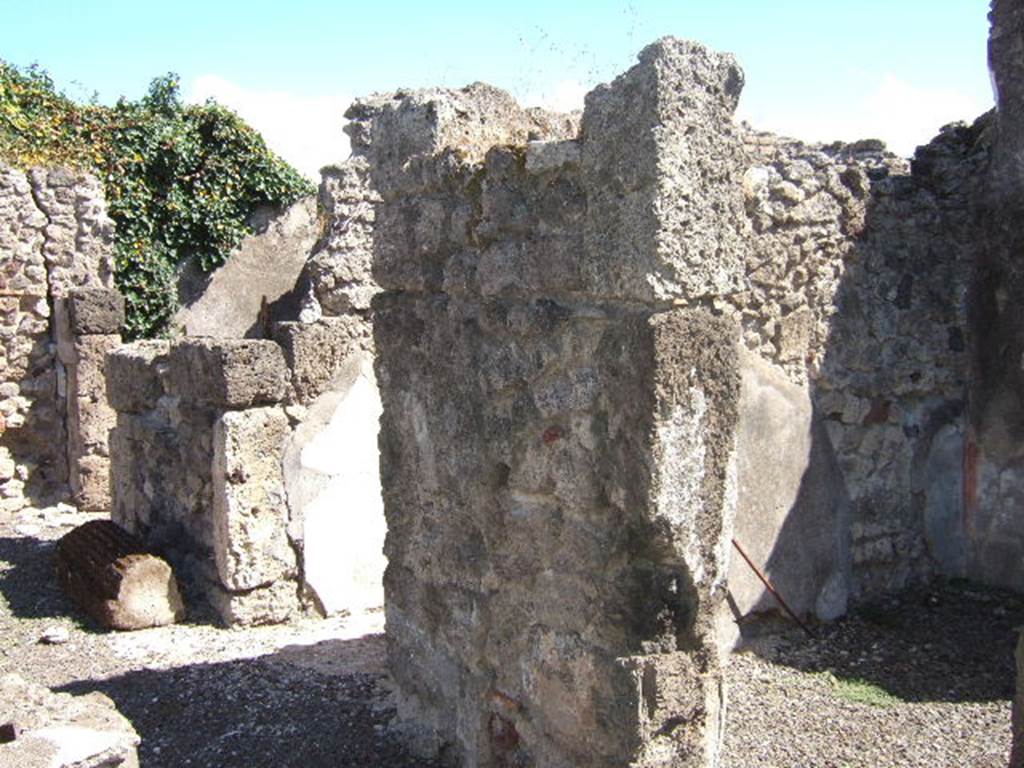 VIII.6.11 Pompeii. September 2005. Looking south-east towards rooms on south side of bakery.
Doorway to room “c”, on the right. According to Mau, room “c” had simple decoration on a white background and a floor of opus signinum; a shelf was attached to the right wall and the rear wall. (“c” ha semplicissime pitture a fondo bianco e un pavimento di opus Signinum; al muro “d” e di fondo era attaccata una scansia.)
Entrance corridor.
Doorway to room “b”, on the left. According to Mau, “b” was the panificium: against the east wall was a masonry foot of a large table: the other foot must have been made of wood.
In the rough-covered plastered walls one could see the holes for the supports of three shelves. The floor was made of opus signinum varied with white stones arranged irregularly
(“b” è il panificium; addosso al muro E sta un piede murato della grande tavola : l'altro piede dev'essere stato di legno. Nelle pareti, rivestite d'intonaco grezzo, si vedono i buchi dei mutuli per tre scansie. Il pavimento è formato di opus Sìgninum variato da pietruzze bianche disposte irregolarmente.) See BdI, 1884, Page 138-9