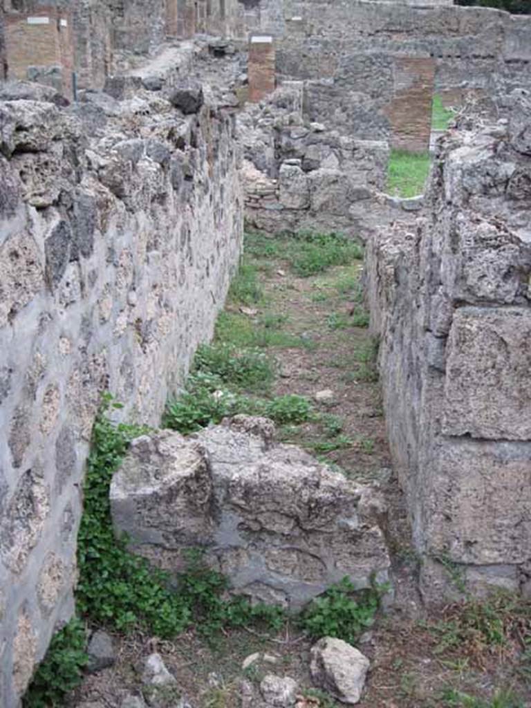 VIII.7.10 Pompeii. September 2010. Corridor looking east towards road (low wall block in foreground). This would seem to have been taken from the kitchen, but presumably was not blocked in antiquity ?