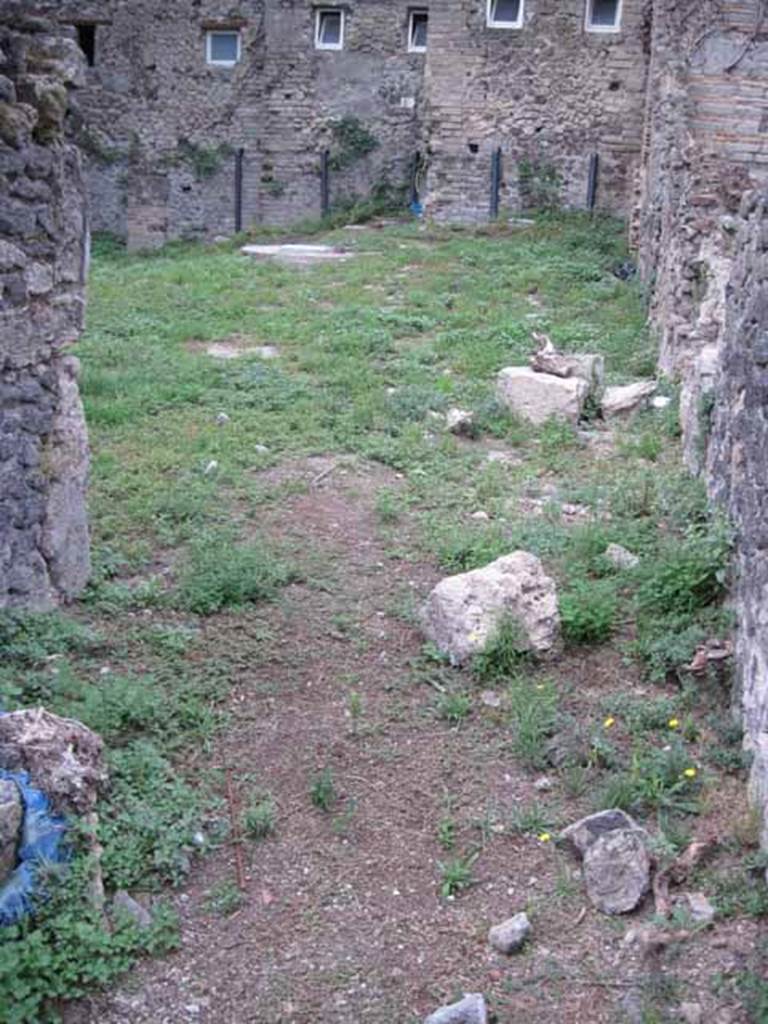 VIII.7.10 Pompeii. September 2010. Looking west from kitchen across garden, linked to VIII.7.6 and VIII.7.11.
In the upper centre, near the modern wall, would have been the latrine.
In this garden, near the south wall, there would have been another triclinium that had a pergola in antiquity.
Photo courtesy of Drew Baker.
Site of kitchen, described by Eschebach as having hearth, well and lararium.
See Eschebach, L., 1993. Gebäudeverzeichnis und Stadtplan der antiken Stadt Pompeji. Köln: Böhlau. (p. 389)
According to Boyce, in the wall of the kitchen there was a niche and beside it was a lararium painting.
It represented a sacrificial scene with the Genius and the tibicen, one on each side of an altar.
On either side of them was a Lar. In the lower zone was a single serpent beside an altar.
See Boyce G. K., 1937. Corpus of the Lararia of Pompeii. Rome: MAAR 14. (p.78, no.377).
See Sogliano, A., 1879. Le pitture murali campane scoverte negli anni 1867-79. Napoli: (p.12, no.24, “badly preserved”).
According to Mau -
“Next to the hearth there was the usual painting of the Lares, and a niche.”
See Mau in BdI, 1875, (p.166 - La quarta casa).
