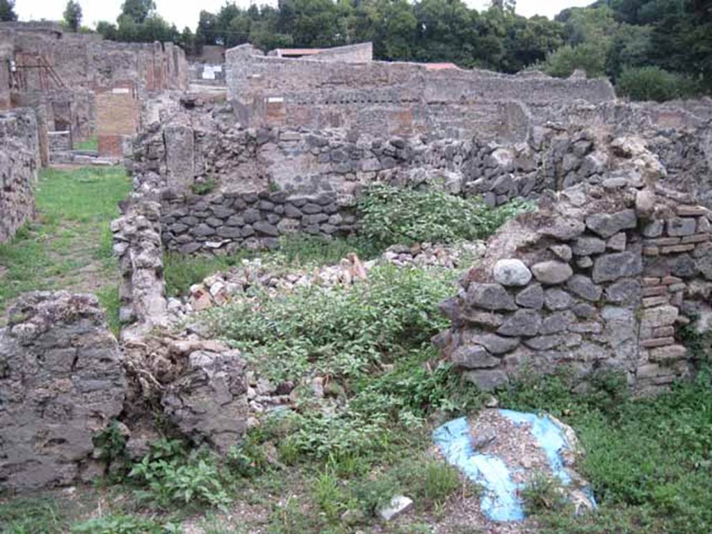 VIII.7.11 Pompeii. September 2010. Small room at rear of triclinium, looking east towards Via Stabiana. Photo courtesy of Drew Baker. According to PARP:PS, in 2007 four circular tanks and one rectangular one were discovered in the rear room in the south west corner of the property. These were from an earlier phase of the development of the use of the property as a tannery. They had been filled in with rubble and a floor was built over them when the area was converted for dining use. See http://www.fastionline.org/docs/FOLDER-it-2008-112.pdf