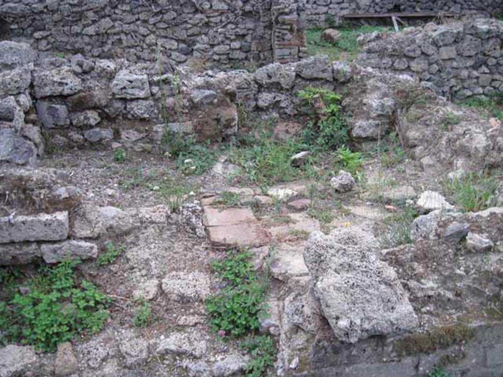 VIII.7.12 Pompeii. September 2010.
Remains of kitchen (?) area, the third room south of corridor, with feature of raised platform with tiled top. Photo courtesy of Drew Baker.
According to Mau, this is one of the two small rooms, but no mention of a kitchen area.
See Bullettino dell’Instituto di Corrispondenza Archeologica (DAIR), 1875 (p.169).
According to PARP:PS – there was a hearth/cooking facilities (no.6 on their plan) against the north wall in the rear area.