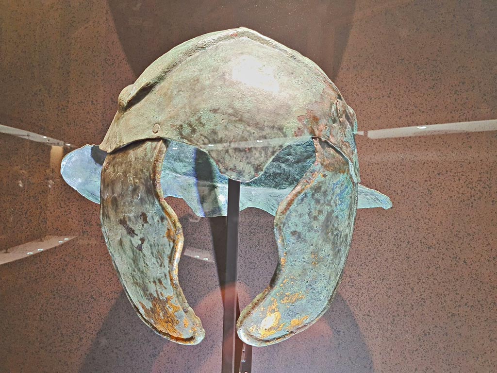 VIII.7.16 Pompeii. Helmet with side guards.
Photo taken May 2021 in Naples Archaeological Museum, courtesy of Giuseppe Ciaramella.