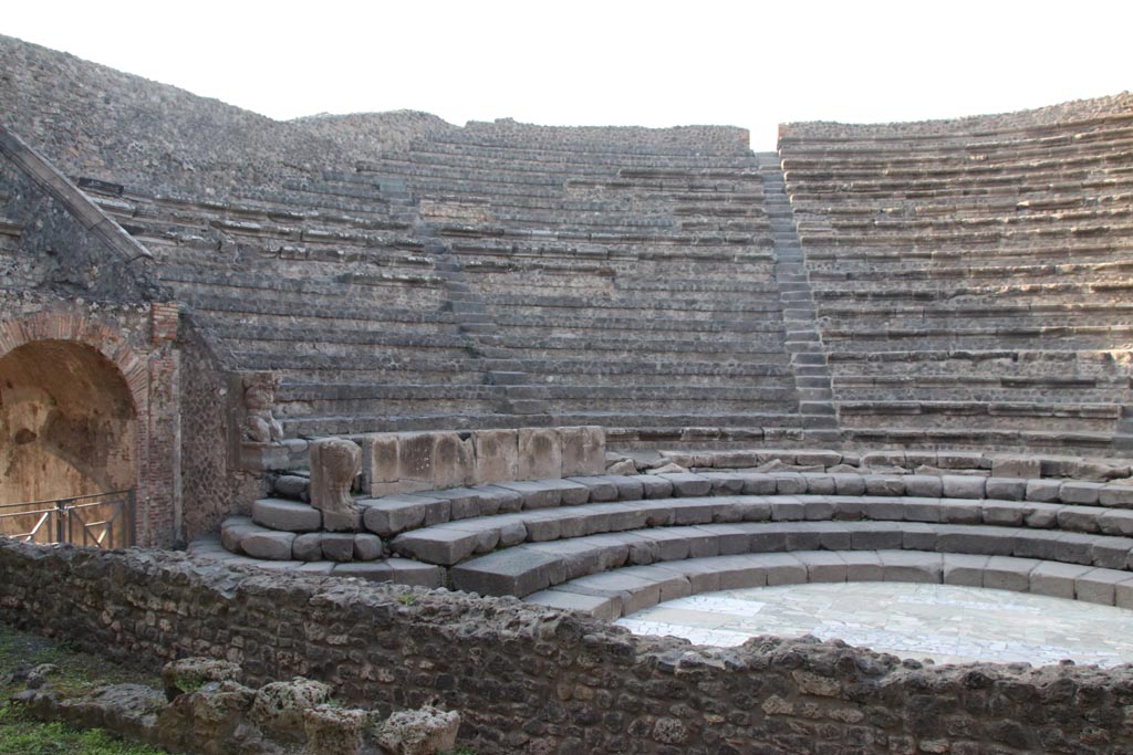 VIII.7.18 Pompeii. October 2023.
Looking west along site of stage, towards Tribunal over arched entrance, on left. Photo courtesy of Klaus Heese.