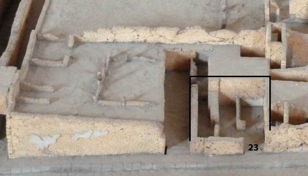 VIII.7.23 Pompeii. Model showing area of the shop, and its location near to VIII.7.22 and VIII.7.24. Model now in Naples Archaeological Museum. According to Fiorelli, this was a shop belonging to the adjoining house, at VIII.7.24. It would have been positioned under the peristyle above. Internally, it had two small rooms, on the west side of the shop.
On the left was the kitchen and perhaps a storeroom. On the right was a latrine adjoining the entrance doorway. See Pappalardo, U., 2001. La Descrizione di Pompei per Giuseppe Fiorelli (1875). Napoli: Massa Editore. (p.134)