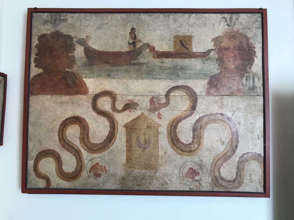 VIII.7.28 Pompeii. April 2019. Found on north wall of the sacrarium.
Ship of Isis, transporting Osiris, and busts of river (Nile?) gods.
Two serpents are moving towards a basket which has a crescent moon symbol on it.
Now in Naples Archaeological Museum. Inventory number 8929. Photo courtesy of Rick Bauer.