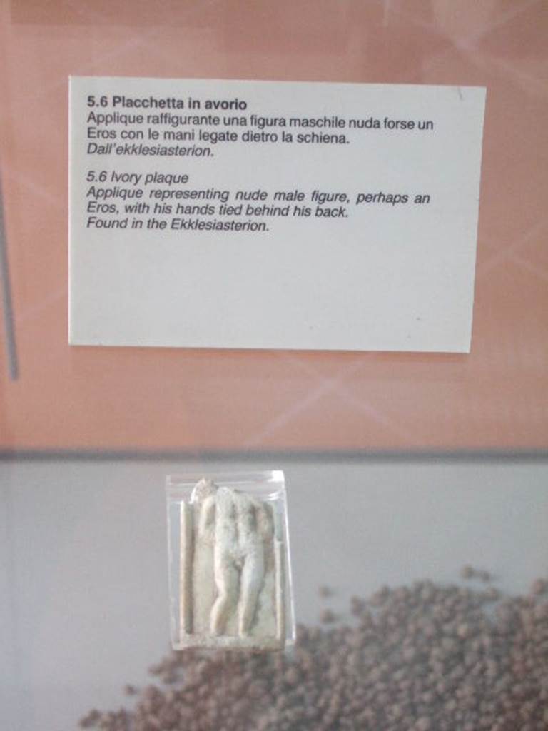 VIII.7.28 Pompeii. Found in the sacrarium or Ekklesiasterion.
The Museum label says the Ekklesiasterion but the Museum website says the sacrarium.
Ivory plaque of male figure with hands tied behind his back.
The presence of a wing, suggested by a ripple on the top-left margin, leads us to believe that this is a Cupid, represented according to the iconography of Eros punished, with the hands tied.
Now in Naples Archaeological Museum. Inventory number s. n. 7.