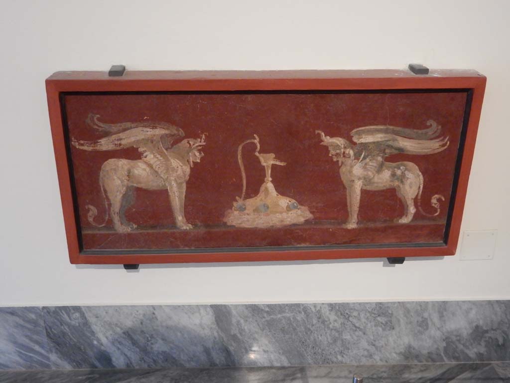 VIII.7.28 Pompeii. June 2019. Painted panel found in the zoccolo of the centre of the south wall in the Ekklesiasterion.
A jug is between two winged androsphinxes. Photo courtesy of Buzz Ferebee.
Now in Naples Archaeological Museum. Inventory number 8563.