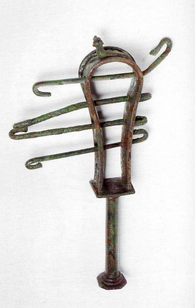 VIII.7.28 Pompeii. The instrument was found on January 4th, 1766 in the Ekklesiasterion.
The sistrum is adorned on the top with a crouched cat and on the sides with lotus flowers.
It was found together with some marble fragments of limbs, among which some of the hand that originally held it and of a marble head of Isis.
Now in Naples Archaeological Museum. Inventory number 2397.