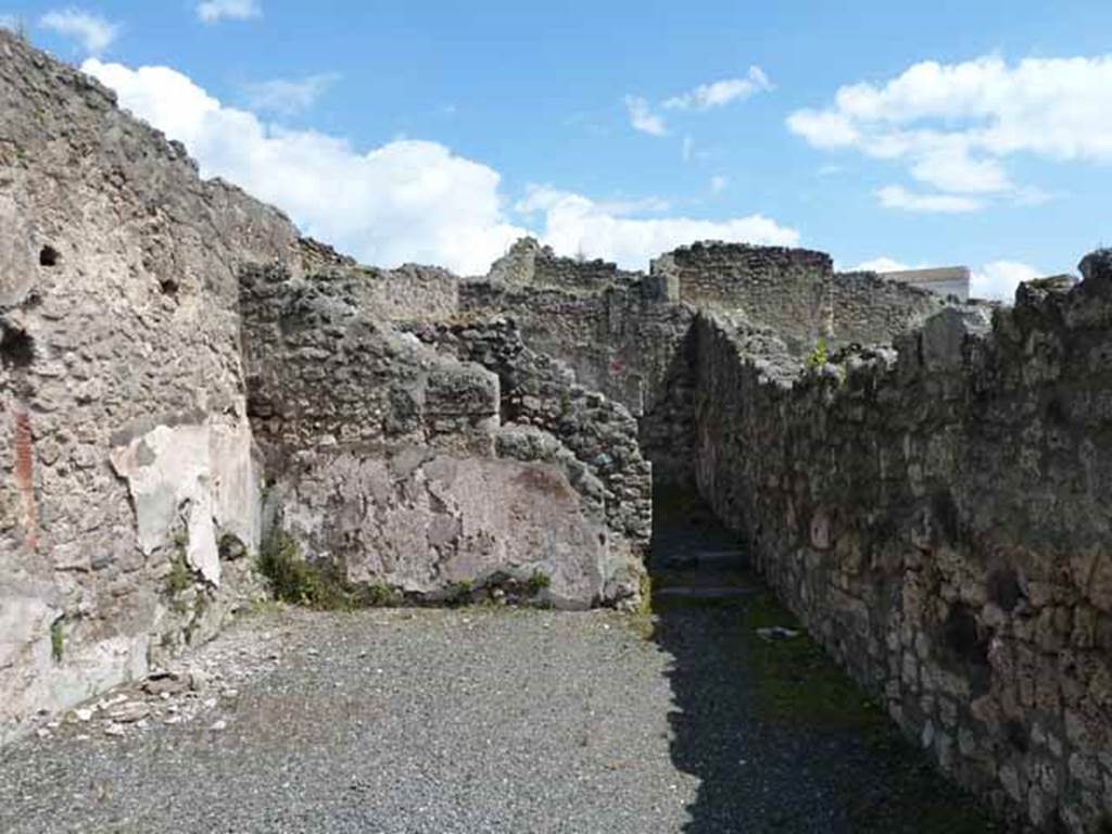 IX.1.1 Pompeii. May 2010 East wall of shop, with doorway to rear room. The only painted decoration remaining on the walls is the red zoccolo/plinth.