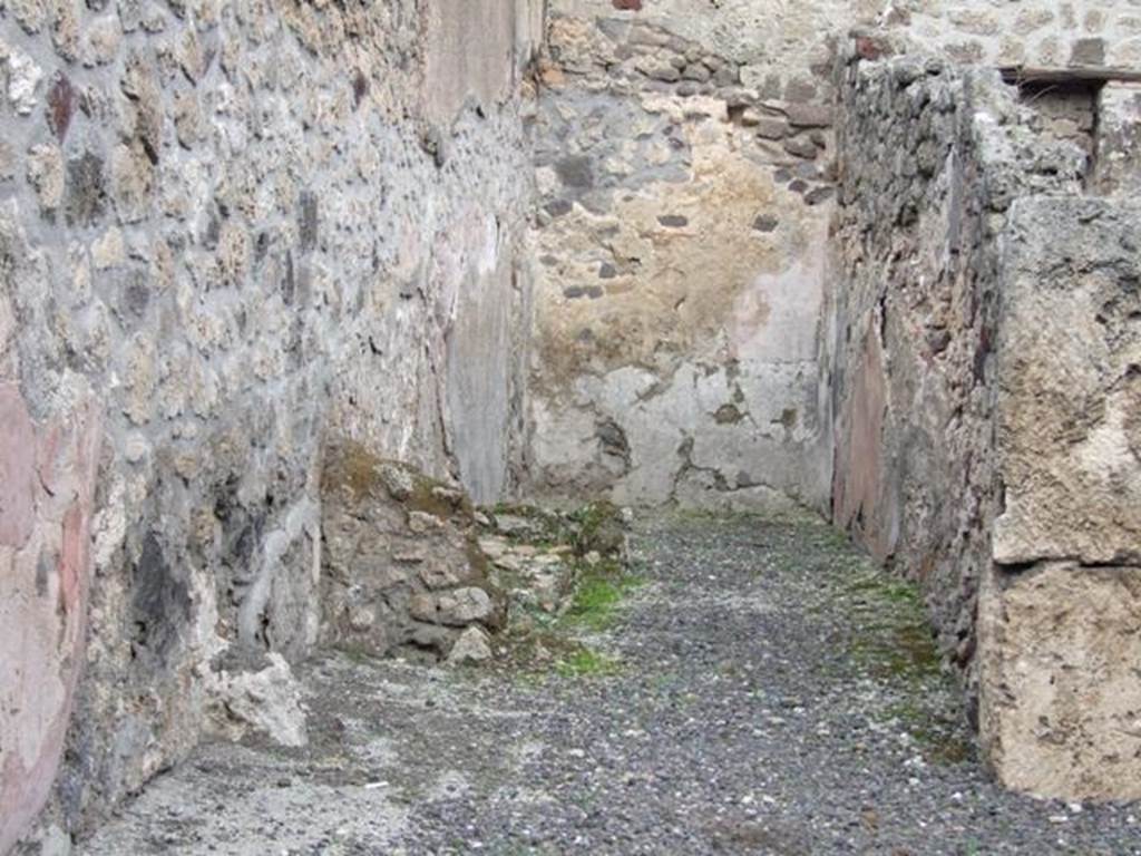 IX.1.8 Pompeii. December 2007. Room in north-east corner. Looking east. This room also contained the latrine, and a lararium, according to Fiorelli. According to Boyce, the lararium was on the east wall painted on a white background with a red border. In the middle, two serpents raised their heads, one on either side of a tile embedded in the wall and projecting out as a shelf for offerings. Two Lares were above the serpents, one on either side, wreathed, wearing red tunic and green pallium and holding rhyton and patera. In the middle below the serpents was a kantharos with a small bird perched on its rim.
See Boyce G. K., 1937. Corpus of the Lararia of Pompeii. Rome: MAAR 14. (p.79)