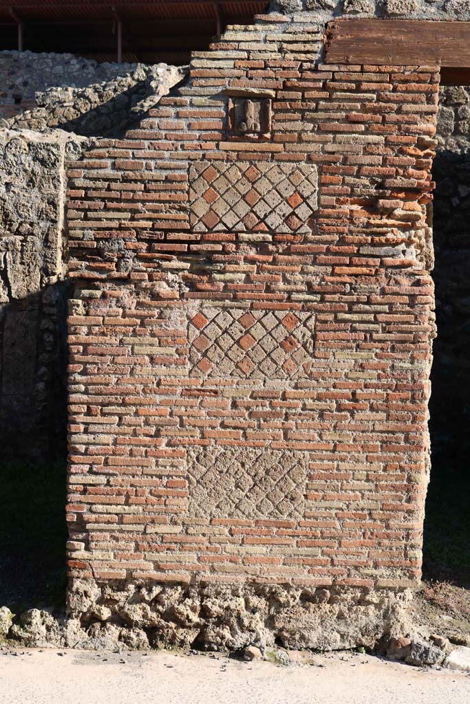 IX.1.13 Pompeii, on left, and IX.1.14, on right. December 2018.
Looking east to pilaster separating two entrances, with a tufa phallus set into a plaque.
Photo courtesy of Aude Durand.