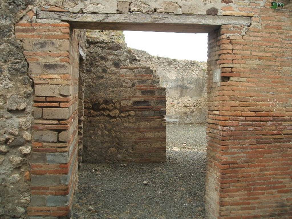 IX.1.31 Pompeii. May 2005. Entrance to small shop. Just visible, the doorway on the left to the kitchen, and doorway on the right to atrium of IX.1.32.