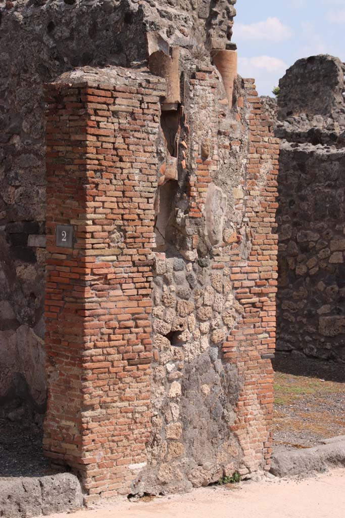 IX.2.2 Pompeii, on left. September 2021.
Pilaster with downpipes from upper floors between IX.2.2 and IX.2.3, on right.
Photo courtesy of Klaus Heese.