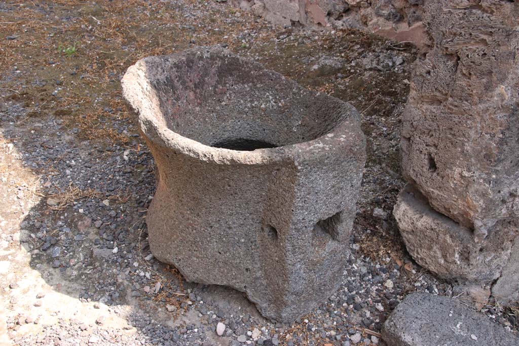 IX.2.4 Pompeii. September 2021.
Fragment of mill (catillus) near entrance to shop, in south-west corner. Photo courtesy of Klaus Heese.