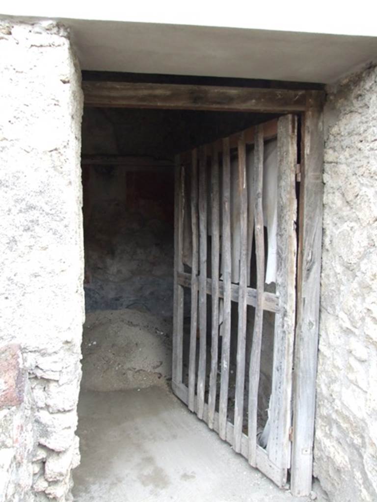 IX.2.10 Pompeii. December 2007. Doorway to cubiculum on south side of peristyle.
According to PPP, in this cubiculum the zoccolo was painted black with panels, and the middle zone of the walls would have been painted red. On the south wall, the central panel was azure blue with the painting of Galatea and Polyphemus (30 x 30).
See Bragantini, de Vos, Badoni, 1986. Pitture e Pavimenti di Pompei, Parte 3. Rome: ICCD. (p.410)
According to Fiorelli, remaining painted in this room were a group of flying Cupids and Psyches, and a figure of a naked Galatea, seen from her shoulders, embracing and joining to Polyphemus, sitting on a rock.
See Fiorelli, G, (1875). Descrizione di Pompei, (p.380).
According to Sogliano, the paintings found here would have been – Eros & Psyche (no.397) and Flying Eros & Psyche (no.398) both on a red background in the cubiculum under the south portico of garden. Galatea, (but nearly destroyed) (no.475).
See Sogliano, A., 1879. Le pitture murali campane scoverte negli anni 1867-79. Napoli: Giannini. (p.68 and p.79)
Also according to Sogliano, from the windowed cubiculum under the south portico of the garden, the following painting was seen – Female crowned figure, with a plate in her left hand, from which it seemed she was taking something with her right hand, (0.29 high red monochrome on yellow background) (no.825, p.159). (Note: this may or may not be from this particular room).
See Sogliano, A., 1879. Le pitture murali campane scoverte negli anni 1867-79. Napoli: Giannini. (p.159)
For description of the upper zone of the wall in this cubiculum,
See Pompejanische Kopien aus Danemark, SAP No. 24, by M.Staub Gierow. (p.231, cat 276)