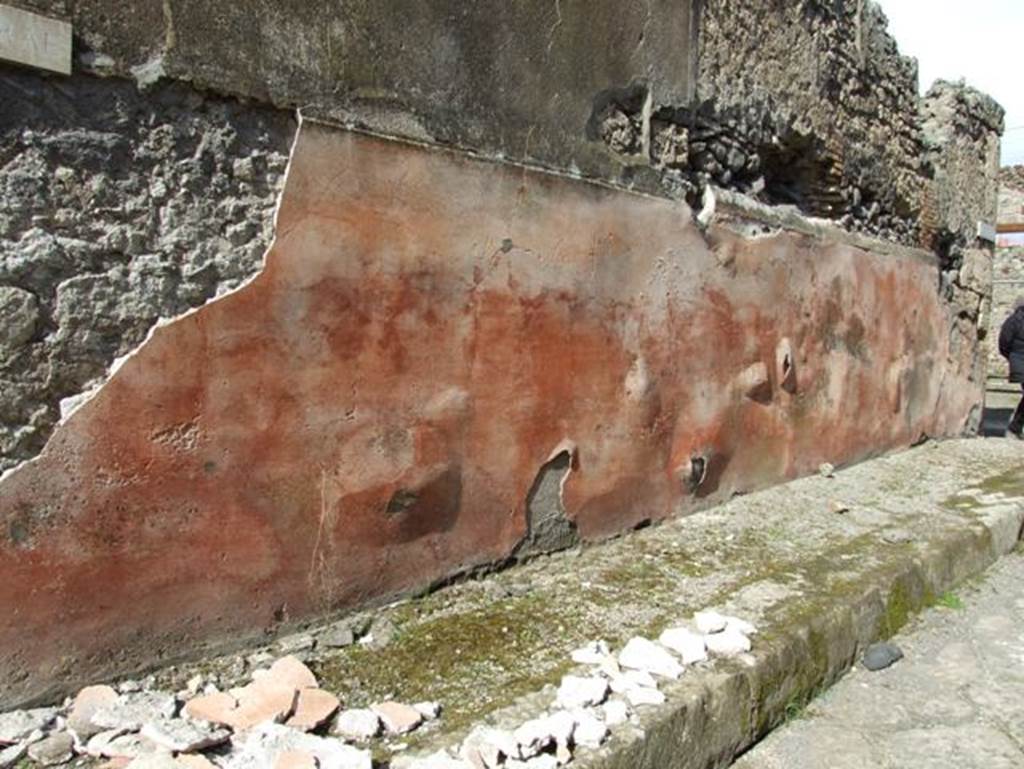 IX.2.16 Pompeii. March 2009. Painted plaster on outside wall, bulging and falling onto the pavement. Looking east.