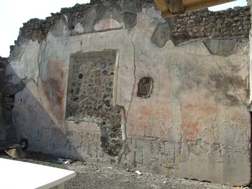 IX.2.16 Pompeii. March 2009. North wall of atrium. According to Bragantini, the floor was made of cocciopesto with a pattern of large white tesserae dots. The dado of the atrium was discoloured or faded. The middle zone of the walls were red, separated into panels by white compartments with candelabra. The frieze was white, and the upper zone would have been red.
See Bragantini, de Vos, Badoni, 1986. Pitture e Pavimenti di Pompei, Parte 3. Rome: ICCD. (p.414, atrio ‘d’)
According to Sogliano, other paintings found on the walls of the atrium apart from Hercules and Hesione, and Bellerophon, were –
Flying cupids (2) (p.59, nos: 324 and 325)
Flying cupid, with a plate in his left hand, and something undistinguishable in his right (p.60, no.331)
See Sogliano, A., 1879. Le pitture murali campane scoverte negli anni 1867-79. Napoli: Giannini.