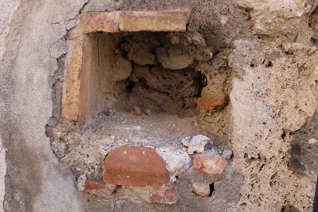 IX.2.21 Pompeii. December 2018.
West side of entrance doorway, possible niche, or as described by Warscher “a hole for barring the door”. Photo courtesy of Aude Durand.