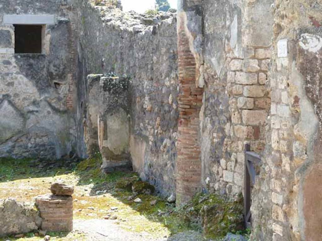 IX.2.27 Pompeii. May 2010. West wall with shrine and entrance through to kitchen and latrine at IX.2.28, on right.