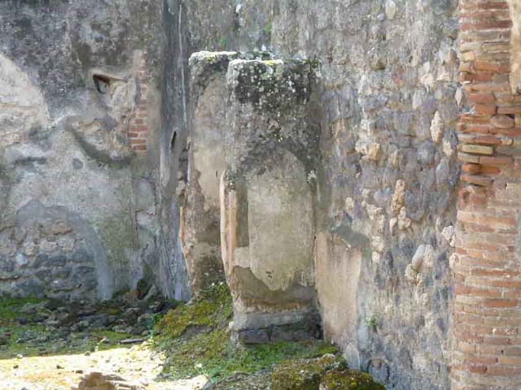 IX.2.27 Pompeii. May 2010. Remains of shrine on west wall.
According to Boyce, the two enclosing walls formed a rectangular niche above a low podium, but none of the floor was preserved. The inside walls are painted blue with red borders. On the ground in front of the shrine stood a square masonry altar.
See Boyce G. K., 1937. Corpus of the Lararia of Pompeii. Rome: MAAR 14. (p. 82)