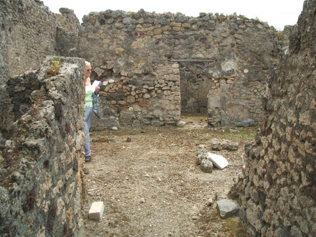 IX.3.23 Pompeii. May 2005. Looking south along entrance corridor to atrium.
According to Fiorelli - “A deserted vicolo, without a pavement existed to the north of the insula, where there were two small houses (IX.3.23 and IX.3.24) on the remains of other ancient dwellings, destroyed perhaps by earthquake. The first of these houses had a latrine next to the entrance corridor, and at the end of this an atrium, sheltered by two wings of roof, that left a space in the middle entirely uncovered, in which because water did not overflow into the part underneath the roof, a small podium was built. To the left, perhaps was the kitchen attached to the latrine, and the triclinium was on the right, followed by a room without closure used as the tablinum, then a cubiculum and the garden, near to which was a storeroom containing the cistern. The last door led into the dormitory with capacity for a few beds.”
See Pappalardo, U., 2001. La Descrizione di Pompei per Giuseppe Fiorelli (1875). Napoli: Massa Editore. (p.147).
See Fiorelli, G, (1875). Descrizione di Pompei, (p.399)