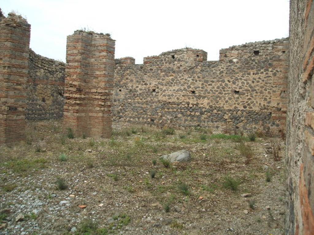IX.4.16 Pompeii. May 2005. Looking north-west from entrance across open area �u�.
According to Mau
�Between the rooms of the Baths and the eastern vicolo, there was only an area of open space, accessible by the two doorways from the eastern vicolo, and from which by a corridor you would pass into the vestibule [�i�].  
In the northern part are 3 pilasters of brick and limestone cut to look like masonry bricks, and it seems that they should have supported a roof  that in the guise of a portico would have covered the north side, and a part of the west side�. 
See BdI, 1878, (p253 of pages 251- 254). 
