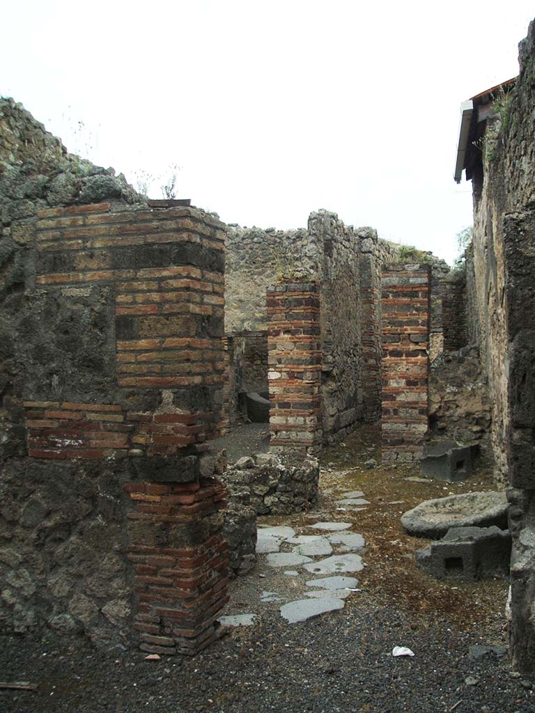 IX.5.4 Pompeii. December 2007.
Looking south into bakery mills area through doorway in south wall of shop-room.