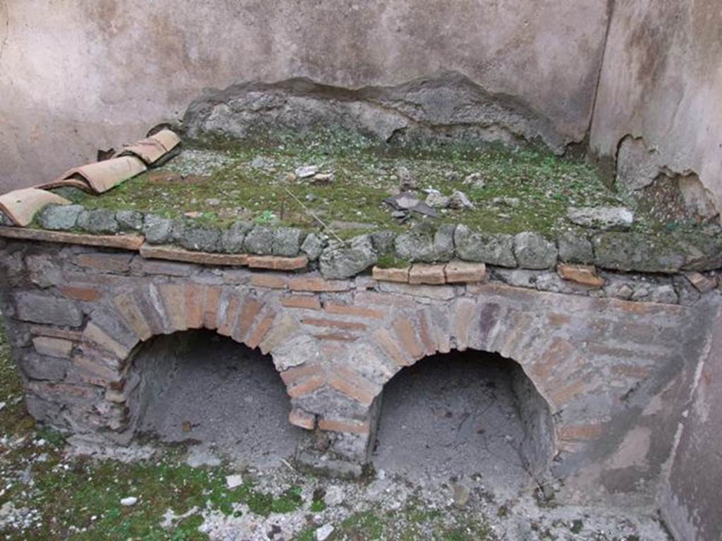 IX.5.6 Pompeii. December 2007. Room p, hearth/bench in kitchen, looking east.
According to Giacobello, traces of a not very legible fresco found on the north wall of the kitchen near the bench were interpreted as a lararium.
This was at the time of excavation. See Mau in BdI 1879, p.116.
See Giacobello, F., 2008. Larari Pompeiani: Iconografia e culto dei Lari in ambito domestico. Milano: LED Edizioni, (p.285).