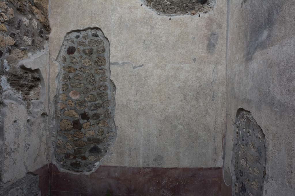 IX.5.9 Pompeii. March 2017.
Room “f”, looking towards east wall with a large hole which would have been made by the ancient searchers of the house.
The walls of this room would have had a red zoccolo, showing painted plants in panels edged with “carpet borders”. The middle zone was painted white, divided into two panels by a central compartment with a painted candelabra.
In the panel on the right (south side) was a painting of masks crowned with foliage.
Foto Christian Beck, ERC Grant 681269 DÉCOR.