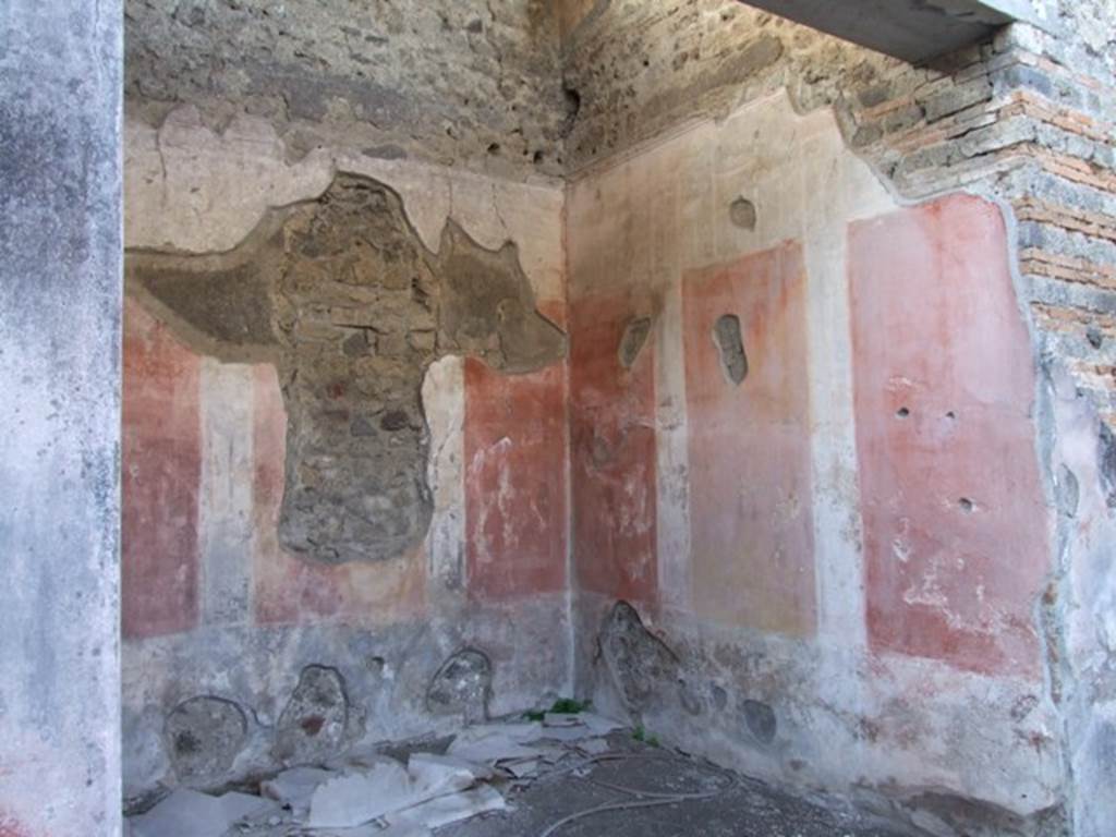 IX.5.11 Pompeii. December 2007. Room 8, ala, on west side of atrium, north-west corner.
According to Bragantini, the lower plinth and zoccolo of the walls in the ala were black. The zoccolo was divided into panels with hanging garlands separated by narrow compartments with painted plants. The middle zone of the walls contained a yellow central panel, and red side panels. On the north and south walls, each panel contained a painted medallion. On the west wall, the side panels contained a vignette of a cupid. The upper zone of the walls was white.
See Bragantini, de Vos, Badoni, 1986. Pitture e Pavimenti di Pompei, Parte 3. Rome: ICCD. (p.472, ala ‘e’)