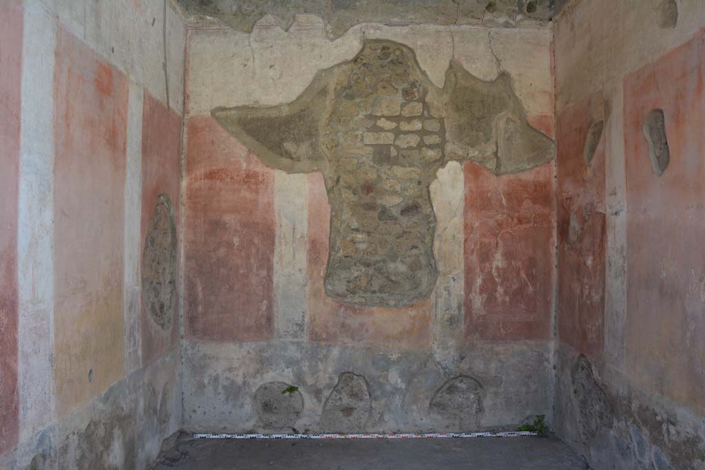 IX.5.11 Pompeii. May 2017. Room e, looking towards west wall.  
Foto Christian Beck, ERC Grant 681269 D�COR.
According to Bragantini (1979) �
West wall with hole, the zoccolo was painted black with panels with �carpet� borders of two parallel lines separated by narrow compartments.
The middle zone had a central yellow panel and red side panels.
The upper zone was white with a stucco cornice. 

