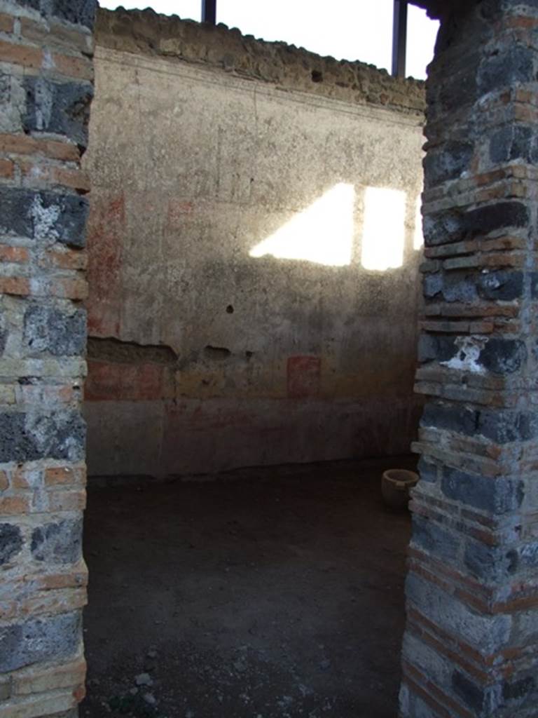 IX.5.11 Pompeii. December 2007. Doorway to room 4, looking east. This room also had a decoration of red and yellow panels, fragmented by ornate architecture. In the yellow panels were small paintings. The one on the north wall (0.51 x 0.44) showed a naked standing Bacchus, crowned with foliage, leaning on a pilaster with his left elbow, inside his elbow was his cloak. In his right hand was a short rod/staff, near to him on the ground was an amphora with a wide neck. Of the other two paintings on the east wall, the first (0.45 x 0.53) showed a Cupid, with two whips, one in each hand following a goat. The second (0.45 x 0.42) also showed a Cupid encouraging a dog to attack a rabbit. The west wall having been holed did not preserve any paintings in its panels.
Whereas on the south, under the window, the yellow plaster that one sees above a most antique decoration (II Style) was decayed. White lozenges (diamonds) were in the red panels, in each lozenge was a painted Cupid, some with rod and pan-pipe, some with crook or with a cornucopia. In the panel of the frieze, finishing above of an elegant cornice of stucco, were painted some isolated figures, around 0.54 high.
Beginning from the north wall, one had -
1.) Female standing woman, with long purple robe.
2.) Satyr crowned with reed, with greenish cloak, having a torch in his right hand and a bunch of grapes in his left hand.
3.) Female figure with green robe, with left hand raised to her head and holding the edge of her cloak.
4.) Female figure with purple robe, with a garland of leaves between her hands.
5.) Naked Satyr, with cloak around his legs, the shepherd’s crook in his left hand, and pan-pipe in his right.
6.) Female figure dressed in dark green robe with a yellow tunic above, holding a lance in the left hand.
7.) Another female figure with red robe and yellowish cloak, who had a fan in the guise of a leaf in her right hand.
8.) Virile naked figure, except for a purple cloak that fell from his shoulders and which was wrapped around his left arm, in his right hand he held an arrow tied to a snare, whose other end he held in his left hand.
9.) Virile figure, badly preserved, with dark green cloak and a lance.
10.) Woman with green robe, gazing intently into a round mirror held in her left hand: the mirror did not have a long handle, but was held on the wrong side.
11.) Another woman with a yellow robe and greenish cloak, who held a basket filled with fruit in both hands.
See Notizie degli Scavi, 1877, (p.248-9)
See BdI, 1879, (p.198-201)