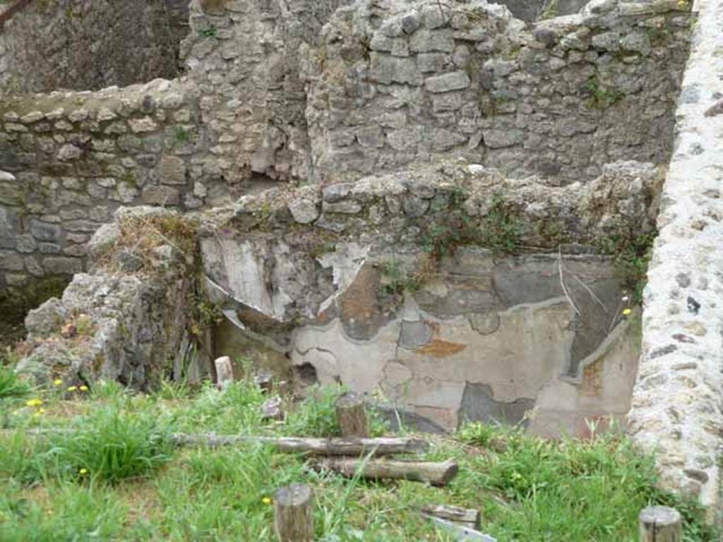 IX.7.16 Pompeii. May 2010. Cubiculum “c”, looking towards west wall.
Looking towards the west wall of room “c” with the remains of painted plaster, on the south side of the atrium.
According to Schefold, on the west wall a painting of Mars and Venus was found. (Helbig 323)
A drawing of the painting can be seen in Schefold, K., 1962. Vergessenes Pompeji. Bern: Francke. (fig.55, 3)
On the east wall, a drawing of the painting of Achilles receiving the arms can be seen in fig.55, 4.
On the south wall, on the left of the photo, a fragment of the wall painting of Cassandra, Hector, was found.
See Schefold, K., 1957. Die Wande Pompejis. Berlin: De Gruyter.
According to Mau, “The walls were of the same character as those in the triclinium and the other cubiculum.
The walls were simply decorated in the III style.
The zoccolo was painted with a black background, the middle of the wall was red, and the upper part was white.
The execution of the decoration was considered inferior, by Mau, to that of the other cubiculum.
In the middle of each wall was a painting in the usual painted pavilion.
- on the left (east) wall – the design showed the interior of a house with a column on the left middle of the painting, a second column was on the right, garlands were hanging on them. In front of this last, a little more to the left, was a young person with heroic stature, with a red cloak (......) In his right hand was a golden helmet. More to the right was a woman (...) Another woman stood beside the base (......) They all looked towards the helmet.
- on the rear wall (south) only a fragment remained: towards the right edge was a figure: the one here had a lance in his right hand (see also Sogliano 560, thought to be Hector) and Helbig 1381, 1391b)
- on the left (west) wall was a painting of Mars and Venus”.
See Mau, in Bullettino dell’Instituto di Corrispondenza Archeologica (DAIR), 1883, (p. 131-133).