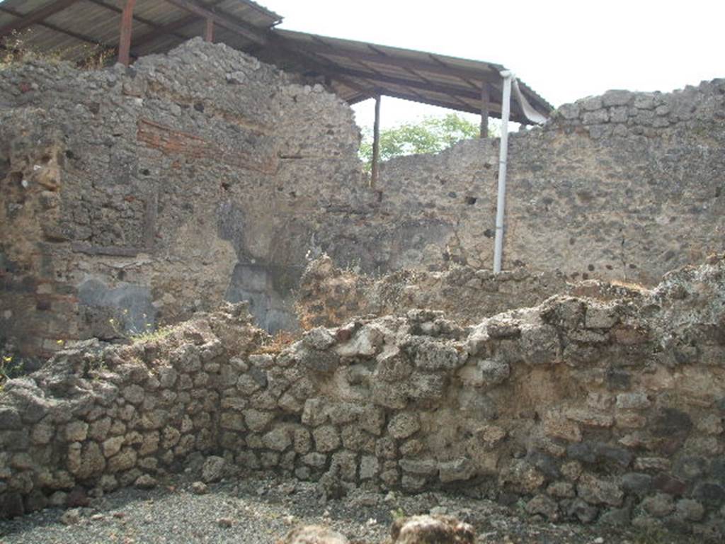IX.7.21 Pompeii. May 2005. Looking south-east across site of small room. At the rear of the south wall is the corridor leading to the latrine.