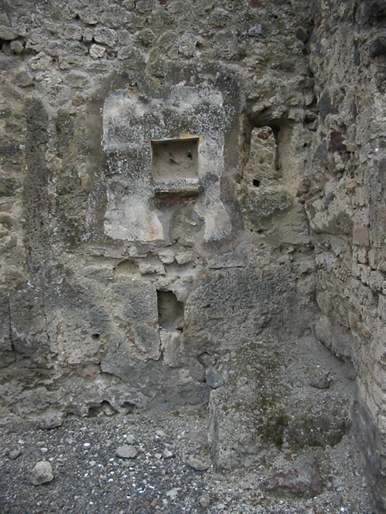 IX.7.21/22 Pompeii. May 2003. Hearth in north-west corner of atrium of IX.7.21.
Above the hearth in the west wall is a panel of white stucco. In the panel is a square niche.
Photo courtesy of Nicolas Monteix.