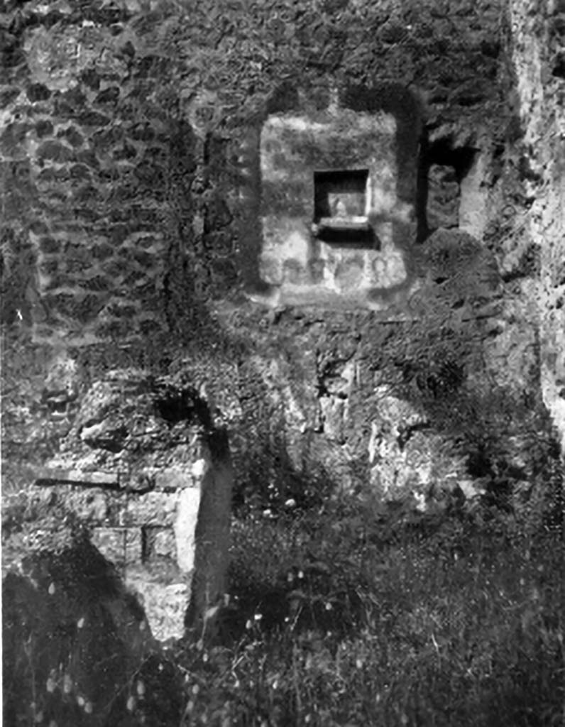 IX.7.21/22 Pompeii. 1937. Lararium in north-west corner of atrium of IX.7.21.
According to Boyce, in the north-west corner of the atrium was the hearth.
Above the hearth in the west wall was a panel of white stucco. In the panel was a square niche.
Its edges were outlined in red against the white background and below it was a cornice.
On the reddish coloured back wall of the niche was painted a white object, which Mau was unable to identify.
He did state that it was not a phallus.
Below the niche was a painted garland of red and green leaves and below it a burning altar with a pine-cone.
On either side of the altar was a yellow serpent.
The serpent on the left had a red crest and beard, the head of the other was damaged.
See Boyce G. K., 1937. Corpus of the Lararia of Pompeii. Rome: MAAR 14. (p.88, no.441, and Pl.4, 4)
According to Giacobello, the painting is no longer conserved.
See Giacobello, F., 2008. Larari Pompeiani: Iconografia e culto dei Lari in ambito domestico. Milano: LED Edizioni. (p.250)
See Mau in Bullettino dell’Instituto di Corrispondenza Archeologica (DAIR), 1882, (p.195)