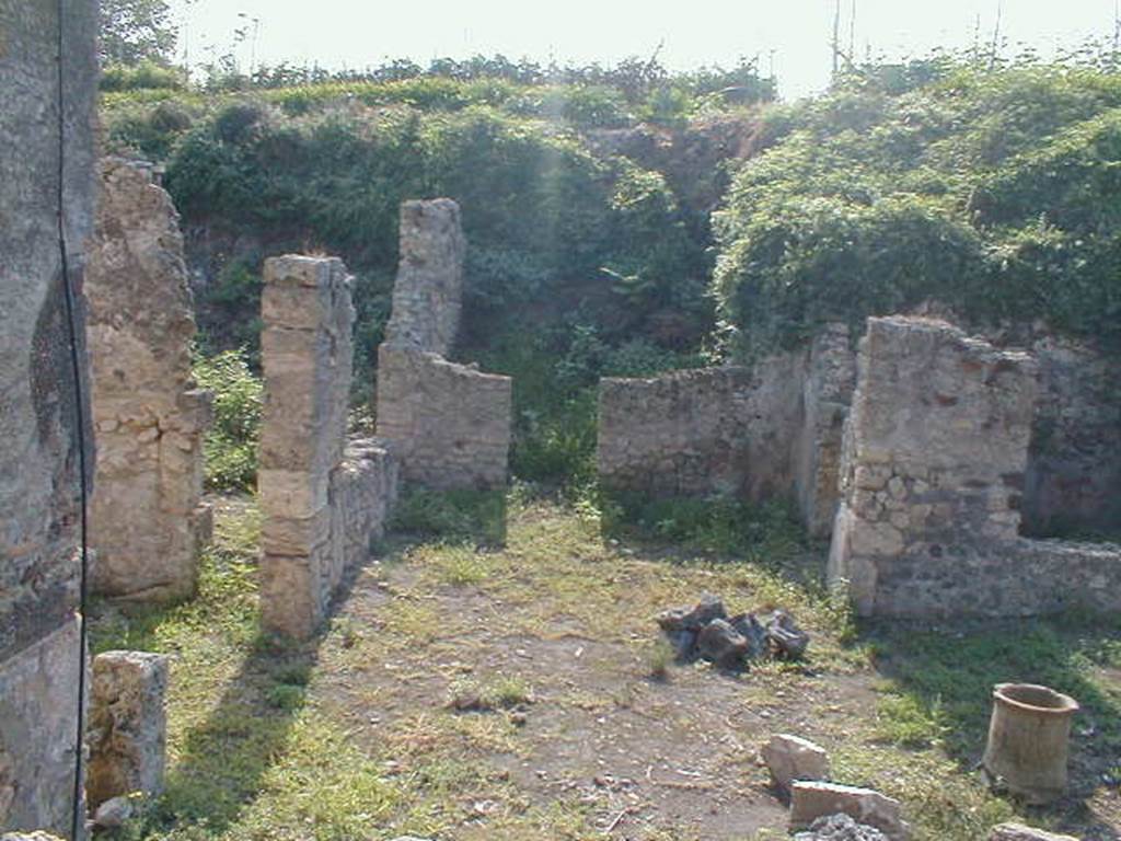 IX.8.c Pompeii. May 2005. Looking south along East Portico, with entrance to Triclinium on the left. The room on south side of garden area is on the right. Photograph taken from IX.8.6.