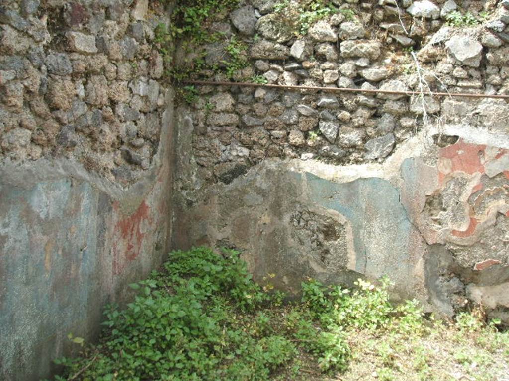 IX.8.c Pompeii. May 2005. Room on south side of garden area. South west corner and remains of painted plaster.