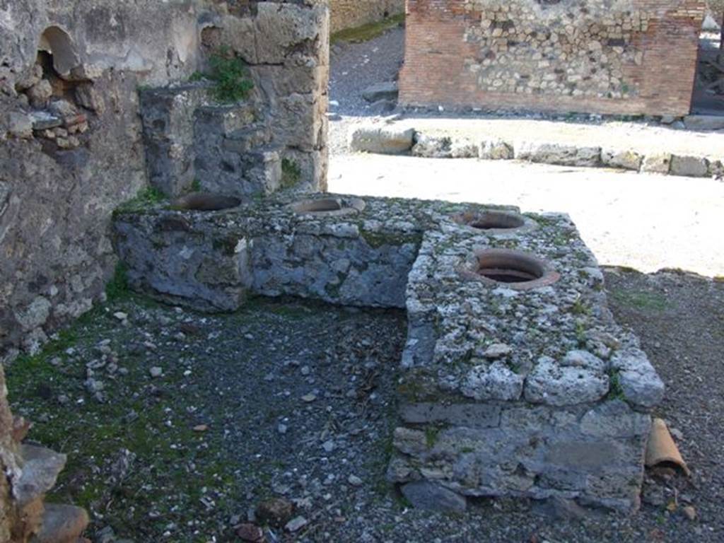 IX.9.1 Pompeii. March 2009. Looking north at counter with 4 dolia, niche and display shelving.