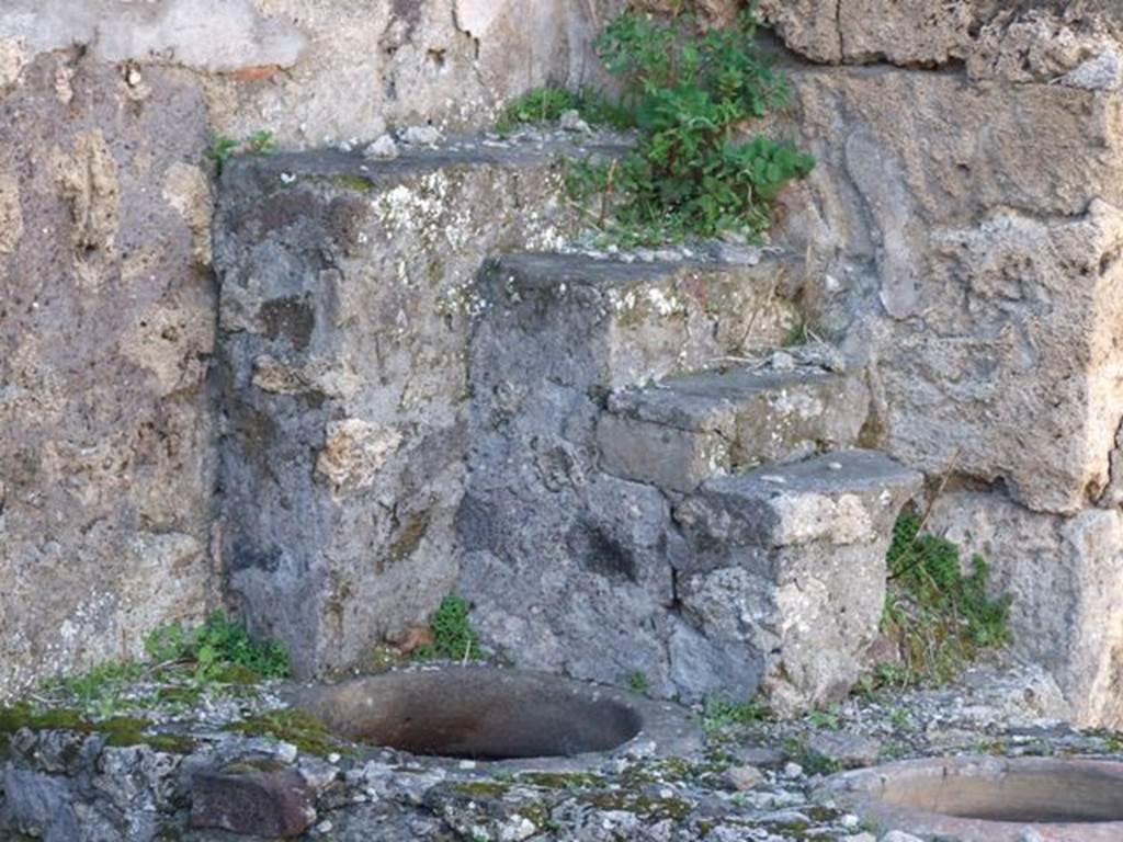 IX.9.1 Pompeii. March 2009. Shelving for displaying crockery and other items, as well as two dolia set in counter for food and drinks.