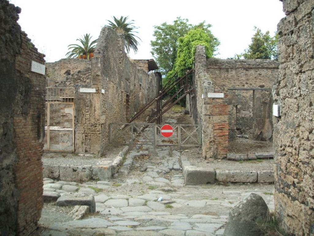 IX.9.8 (Side wall on left). Looking north from unnamed roadway across the Via di Nola, towards V.4 (centre left) and V.5 (centre right). (Side wall of) IX.10 on right