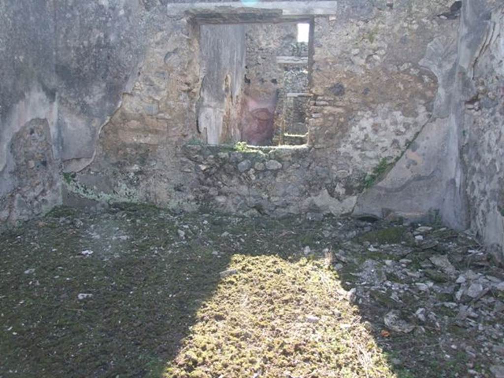 IX.9.12 Pompeii. March 2009. Room 13, triclinium. Looking west through window into room 16, the light yard of IX.9.e. According to NdS, this room was lit by two windows, there would have been another in the south wall overlooking the garden (on the left). This had another circular window above it, which would originally have been rectangular. The flooring would have been of crushed brick (mattone pesto), and the walls were decorated with a black background with red bands. In the centre of the north wall (on the right) was a red panel containing a painting which had partly fallen, and the parts which remained had faded. In the south wall near the doorway to the garden area, (see IX.9.13) was a low masonry hearth, which showed the room originally had another use.
See Notizie degli Scavi, 1891, p.257.